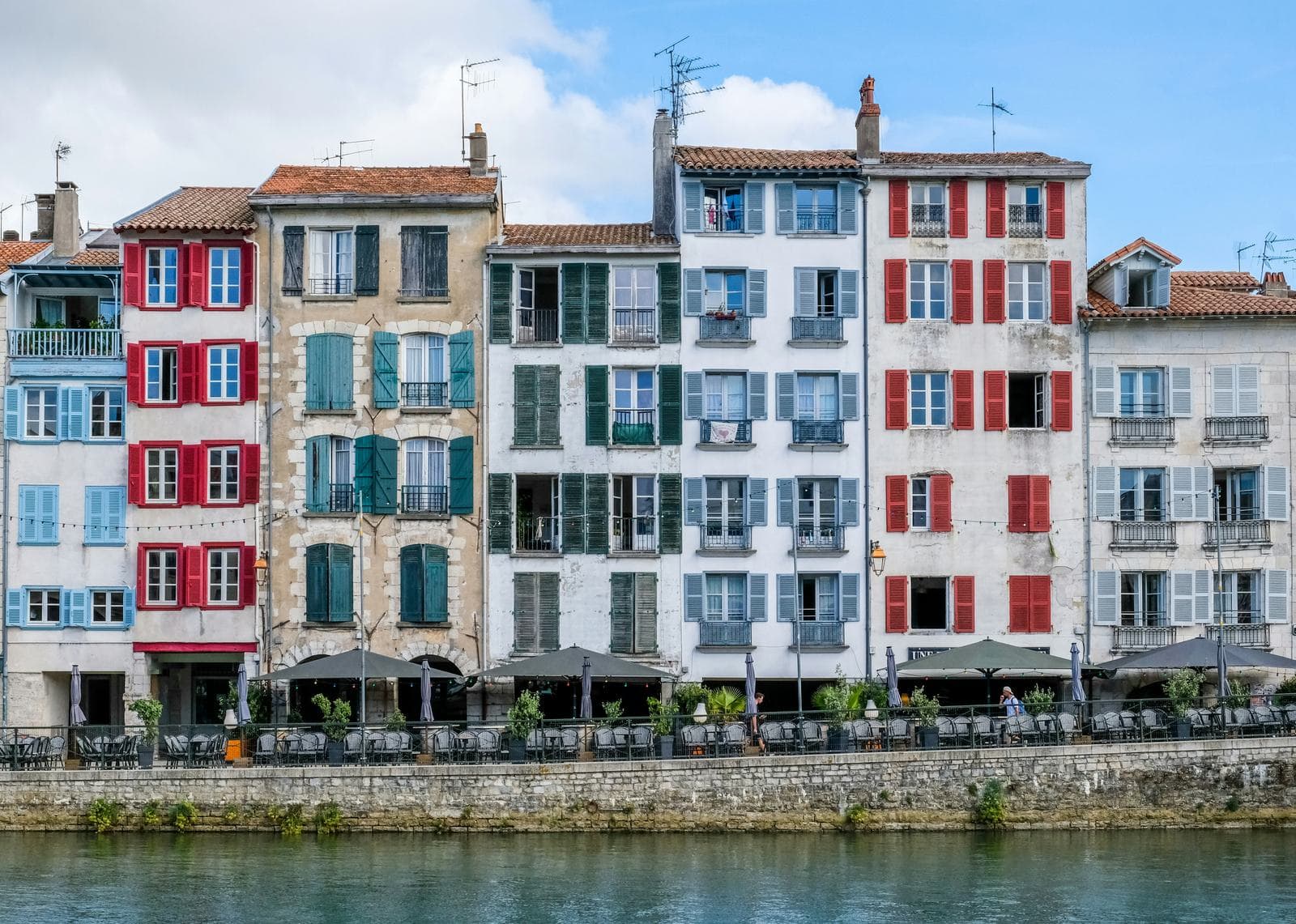 Façades colorées des quais de la Nive à Bayonne — biens en gestion locative au Pays Basque
